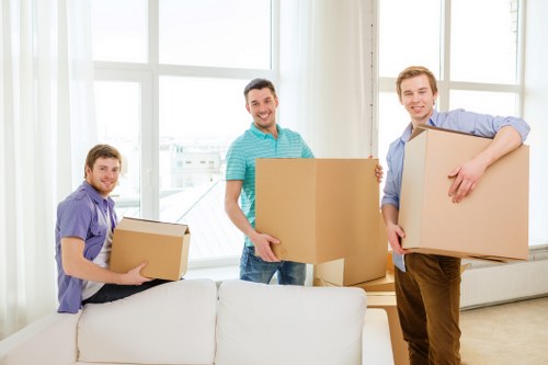 Professional movers carrying furniture in a Kennington home